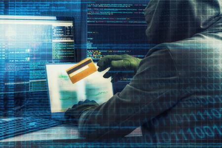 互联网犯罪的概念.黑客编写代码和盗窃信用卡与周围的数字接口照片